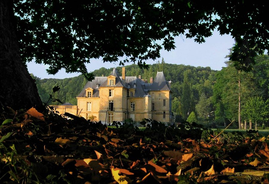 Schloss von Acquigny mit Park und Wasserfläche bei Sonnenuntergang