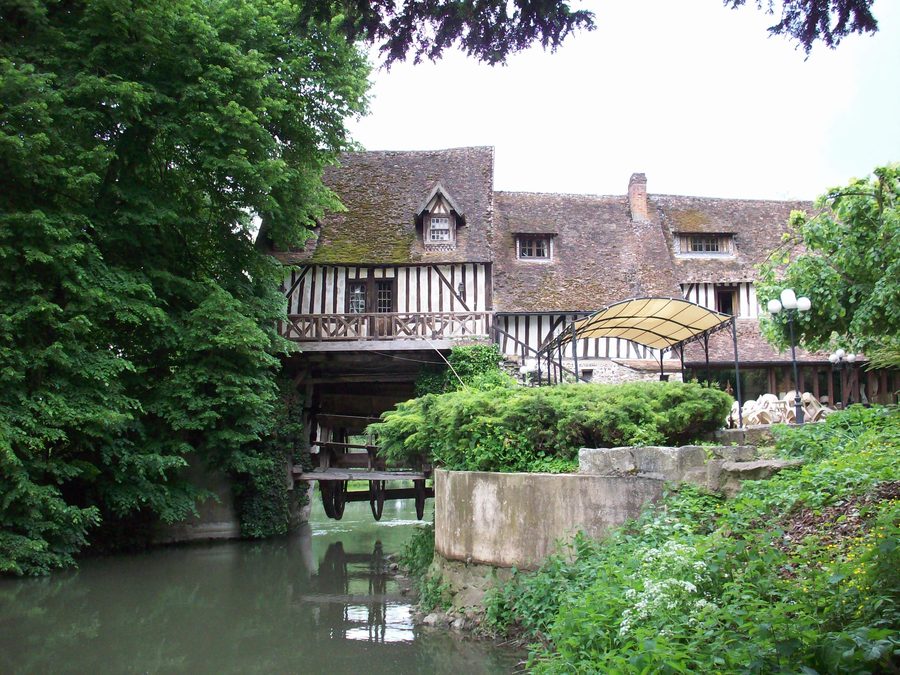 Historische Mühle von Andé mit angehobenem Mühlrad an einem Seine-Arm
