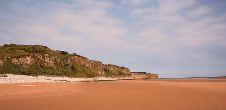 Küste von Omaha Beach mit dem Strand und den steilen Klippen in der Normandie