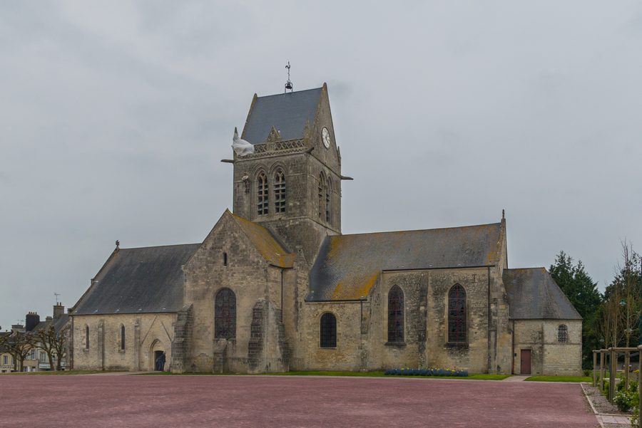 Kirche von Sainte-Mère-Église mit dem Fallschirmjäger-Motiv am Turm
